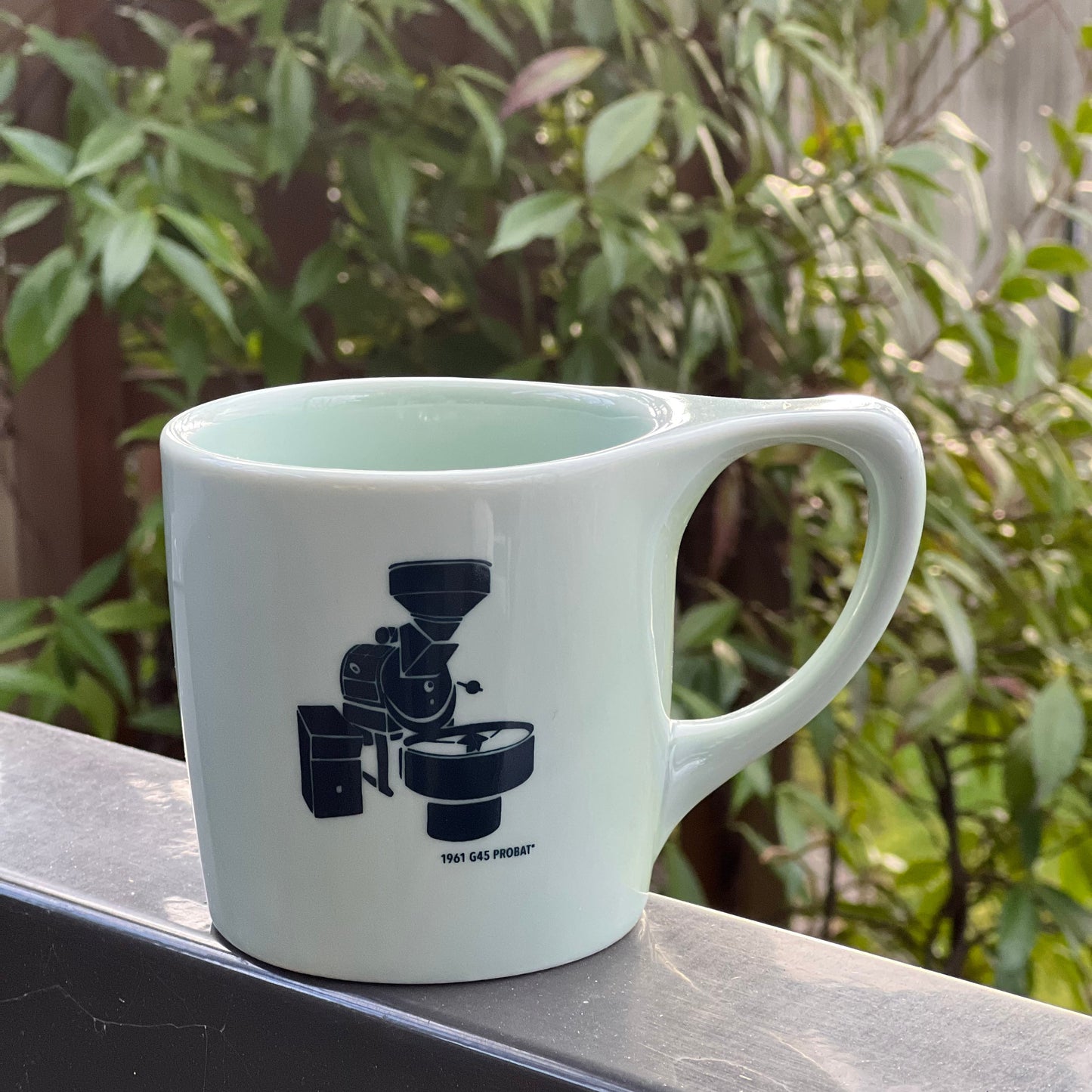 Sage green Lino notnuetral mug with Zoka's Probat roaster decal design on the mug.